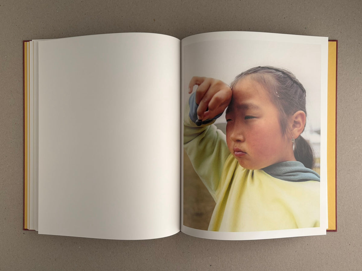 Open copy of süü – Taemin Ha showing a full-page portrait of a child on the right-hand page, with the left page blank.