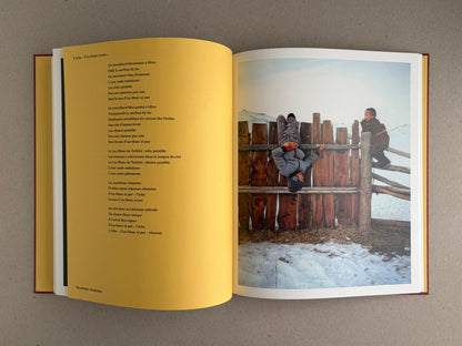 Open spread of süü – Taemin Ha, with a poem on the left page and a winter photograph of two children by a wooden fence on the right page.
