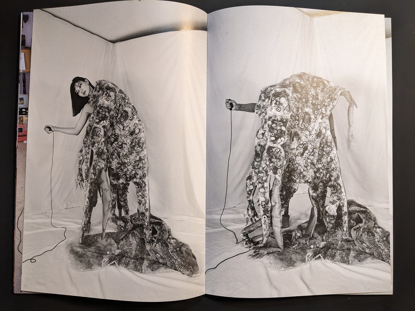 Photographic spread of a hand-sculpture costume with red shoes and prosthetic limbs