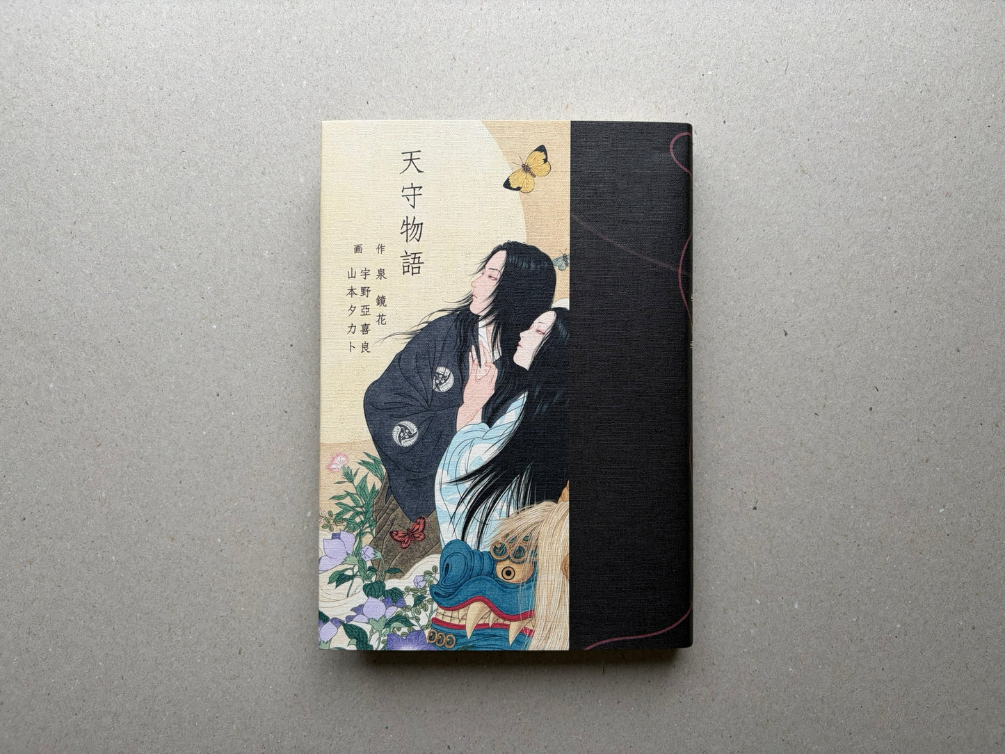 Front cover of Tale of a Castle Keep, with Japanese title text and an illustrated figure against a split cream and black cover.