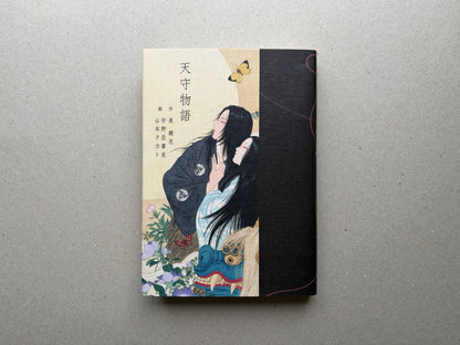 Front cover of Tale of a Castle Keep, with Japanese title text and an illustrated figure against a split cream and black cover.