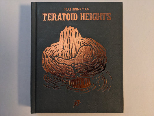 Front cover of Teratoid Heights by Mat Brinkman, black canvas hardcover with bronze foil embossing