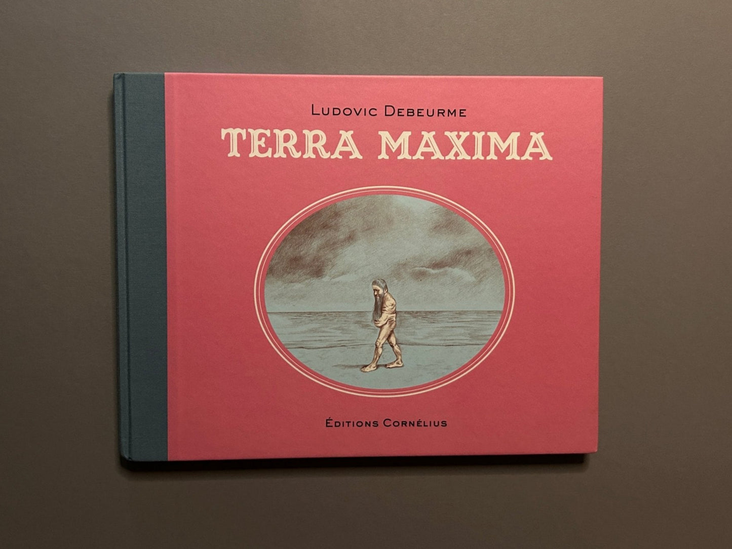 Terra Maxima by Ludovic Debeurme, front cover with pink dust jacket and central oval illustration