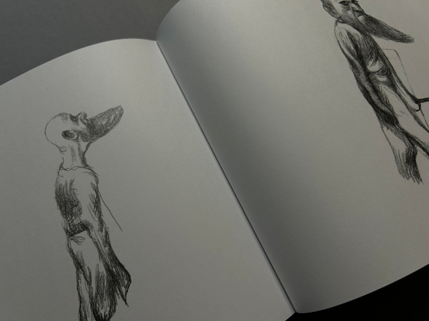 Open Terra Maxima spread with pencil drawings of elongated figures on facing pages
