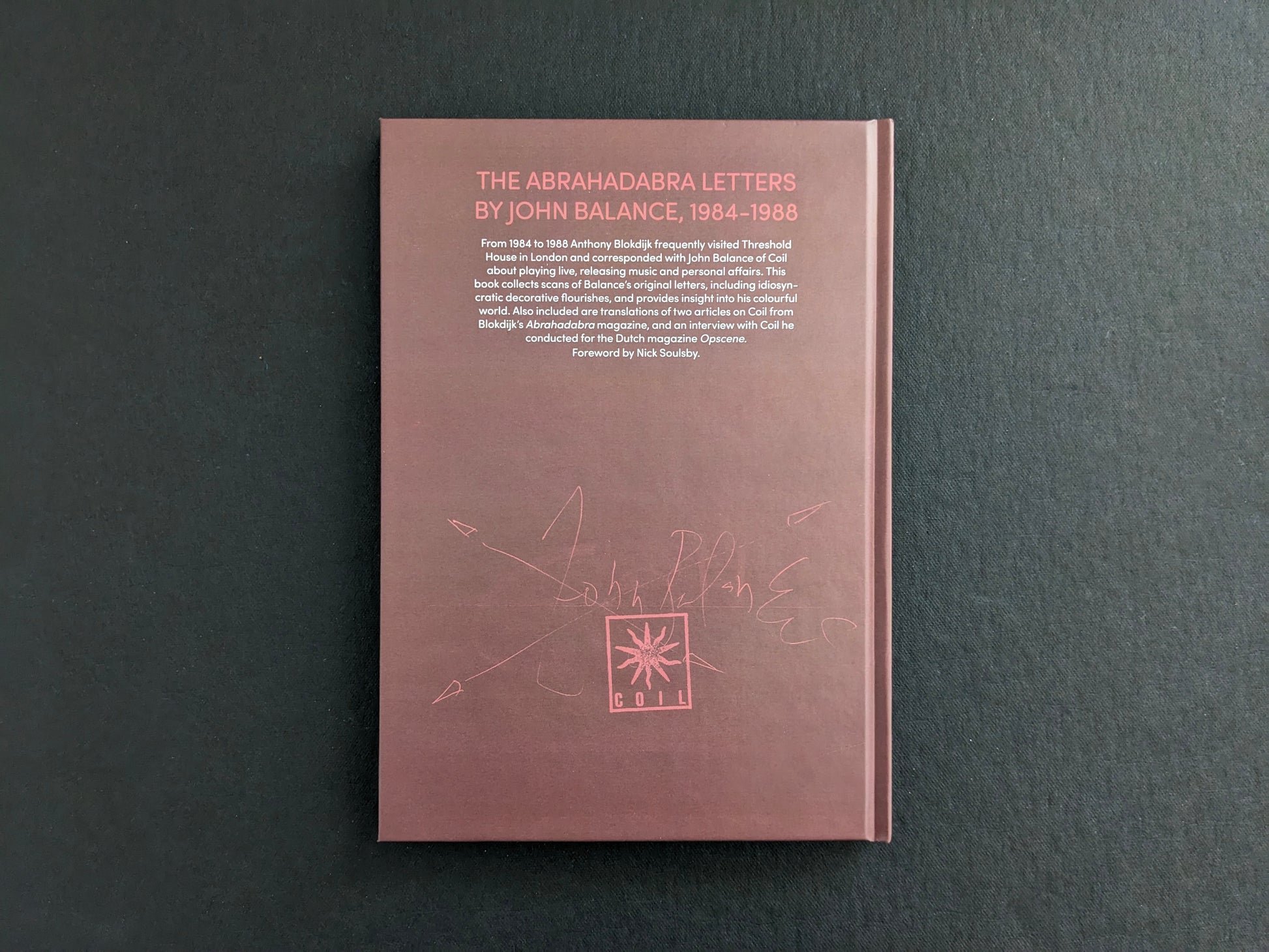 Back cover of The Abrahadabra Letters, brown clothbound boards with printed description and a Coil emblem.