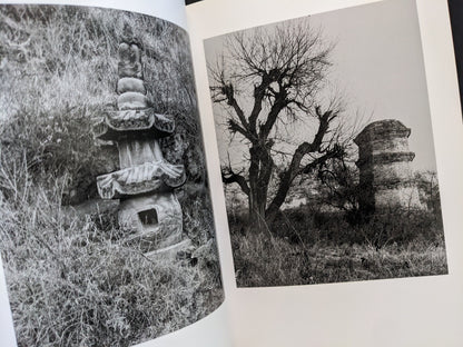 Interior spread with two black-and-white photographs of Buddhist towers in natural surroundings.