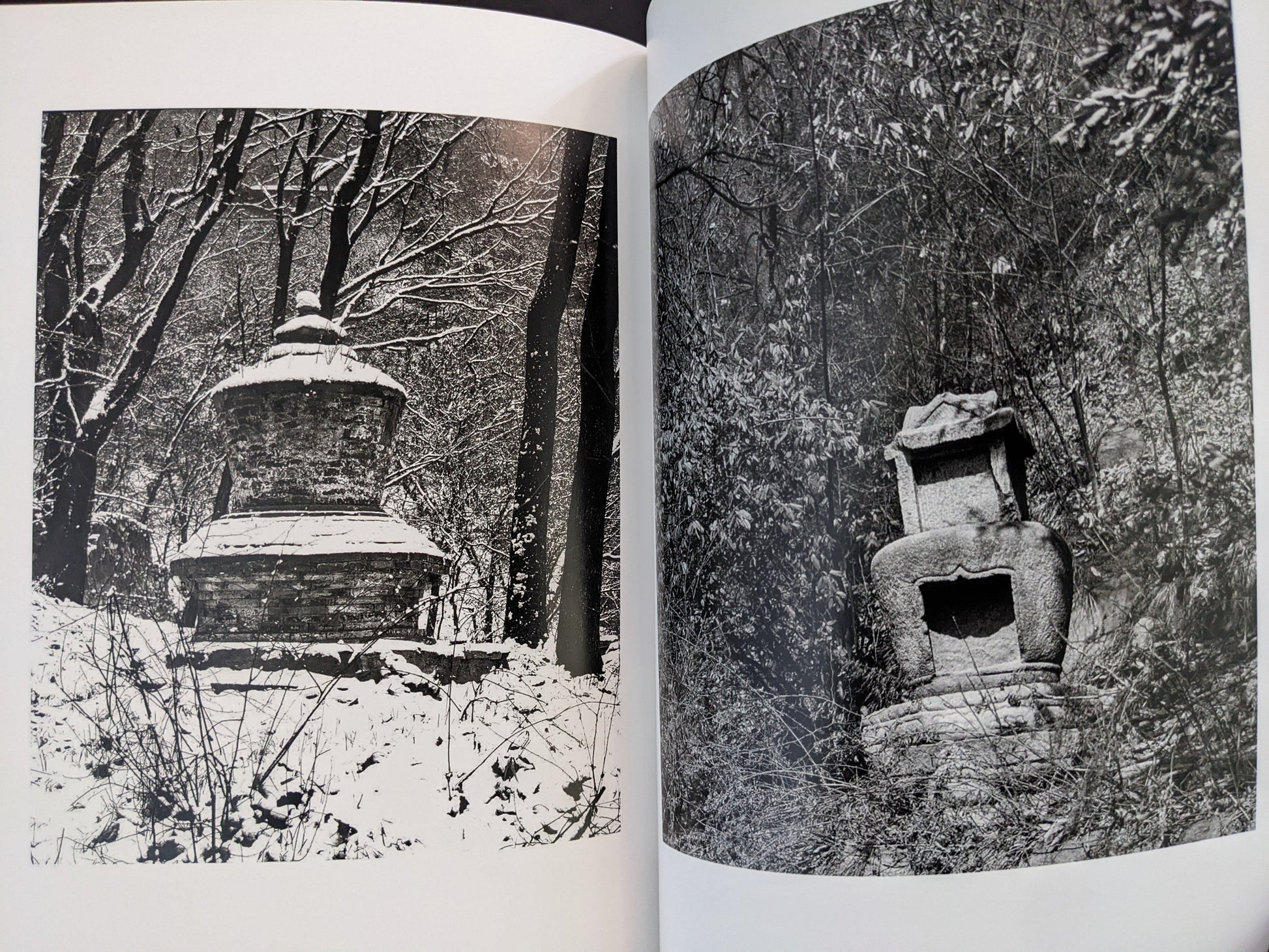 Black-and-white photographs of Buddhist stone towers surrounded by winter trees.