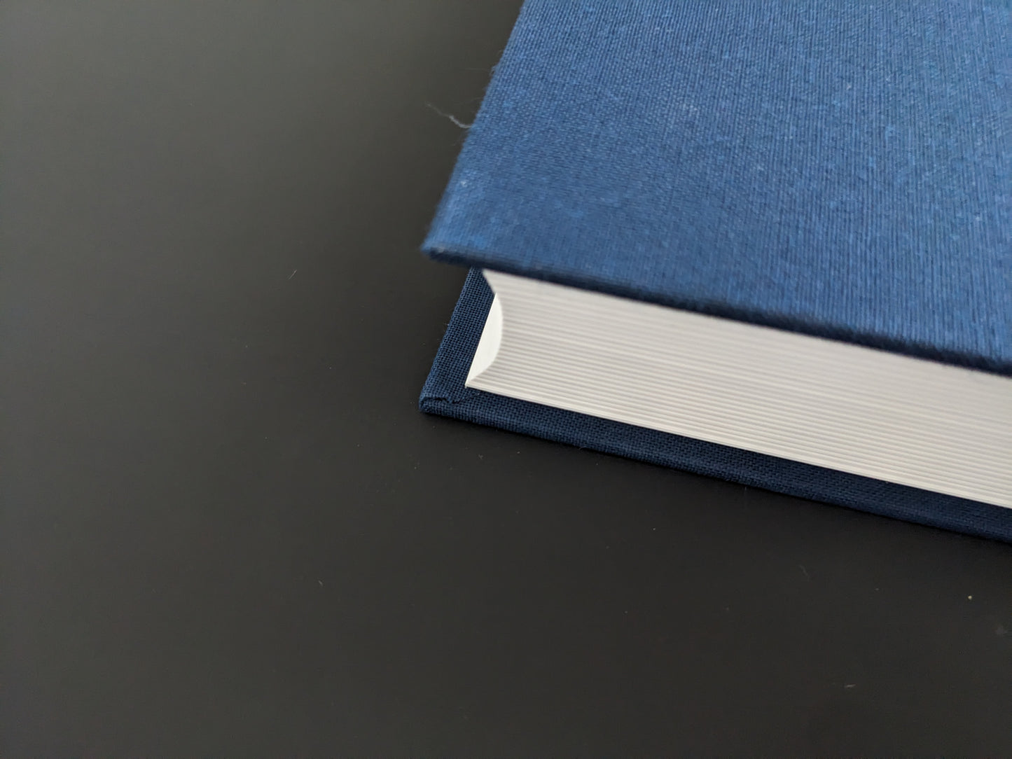 Close-up of book corner with blue cloth binding showing slight wear