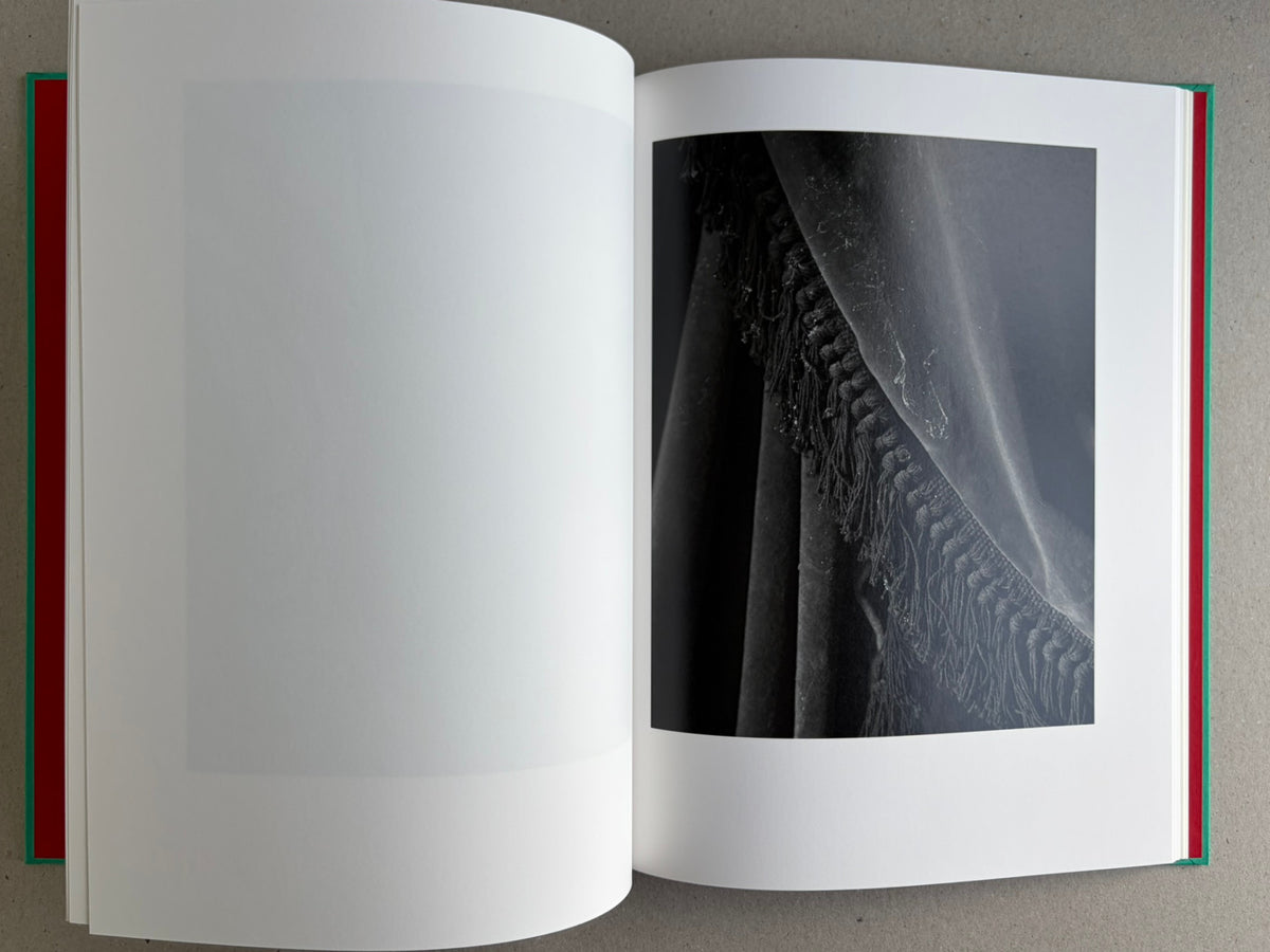 Open spread from The Essential Solitude, showing a black-and-white close-up of draped fabric and fringe on the right page.