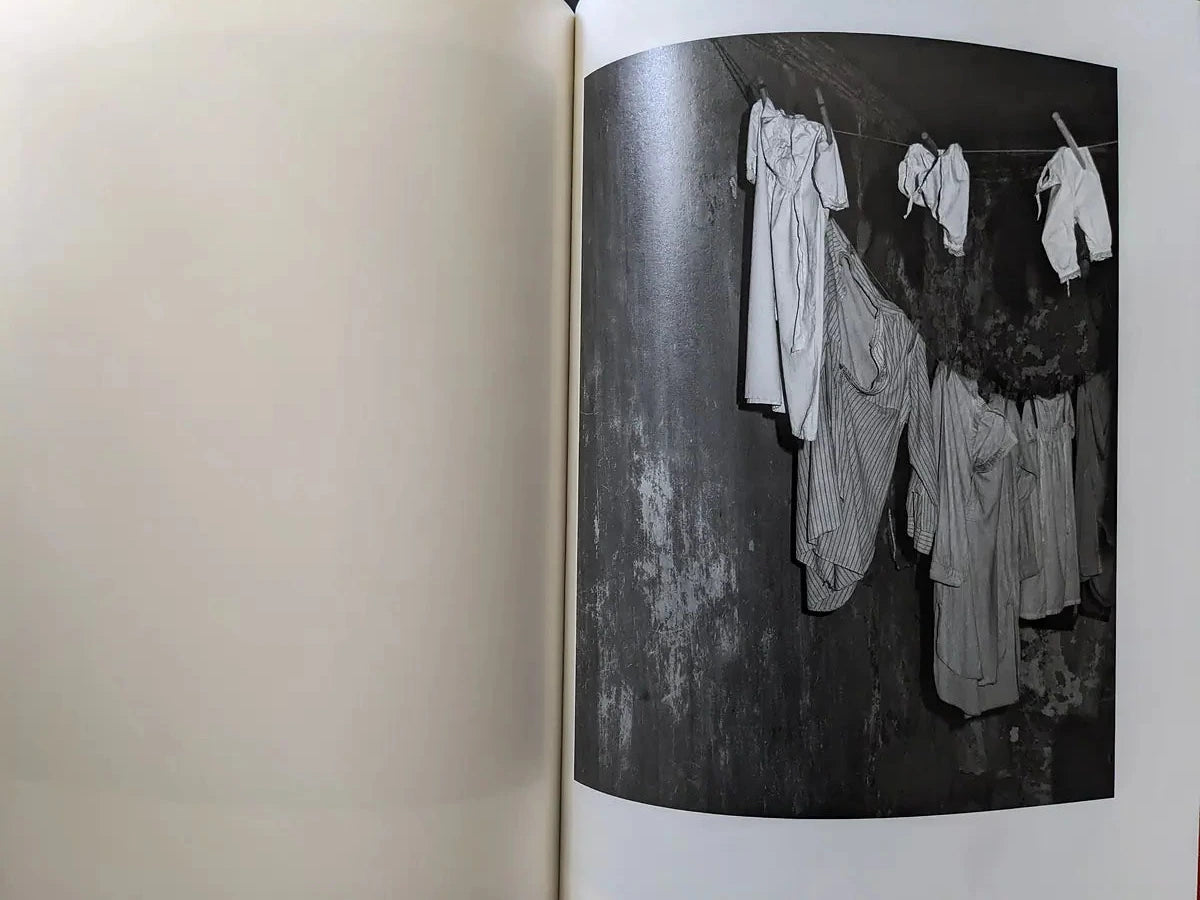 Hanging white garments on a line inside a dim cellar space.