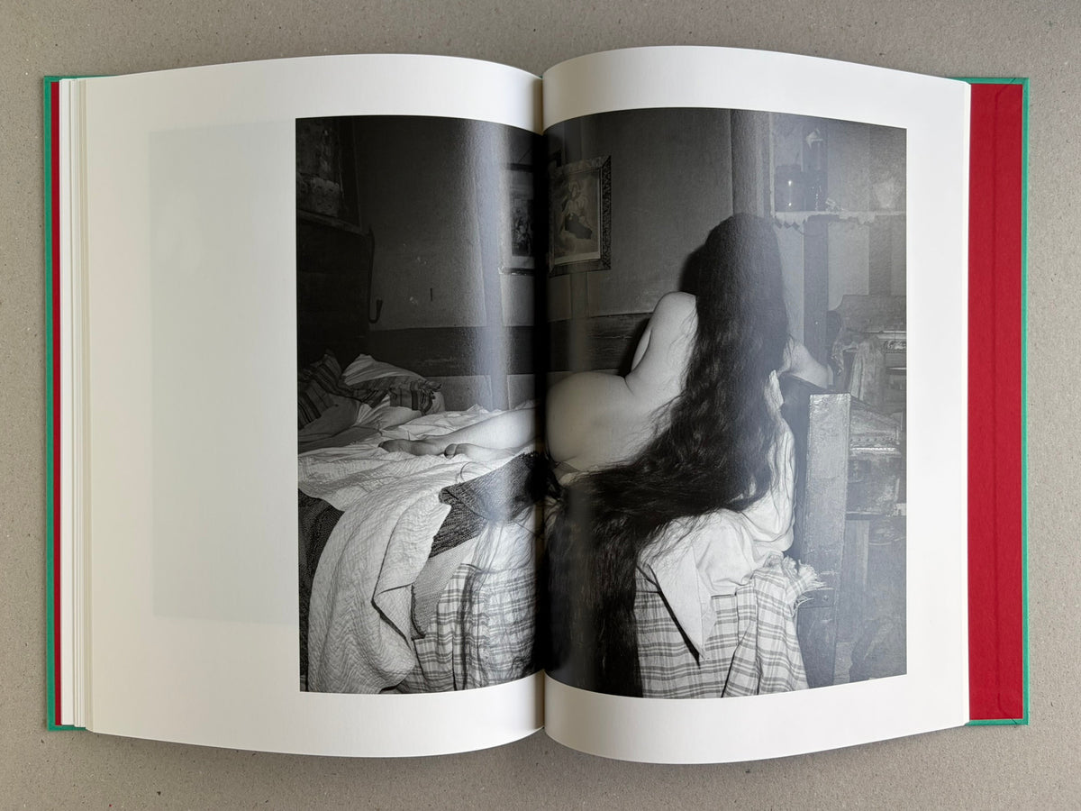 Open spread from The Essential Solitude, showing a black-and-white reclining figure in an interior on the right page.