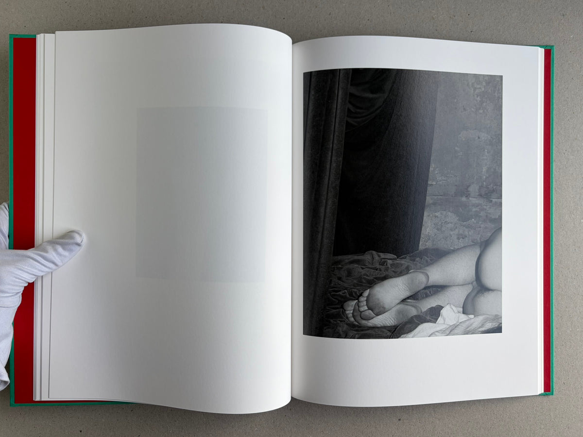 Open spread from The Essential Solitude, with a black-and-white reclining figure’s legs on the right page.
