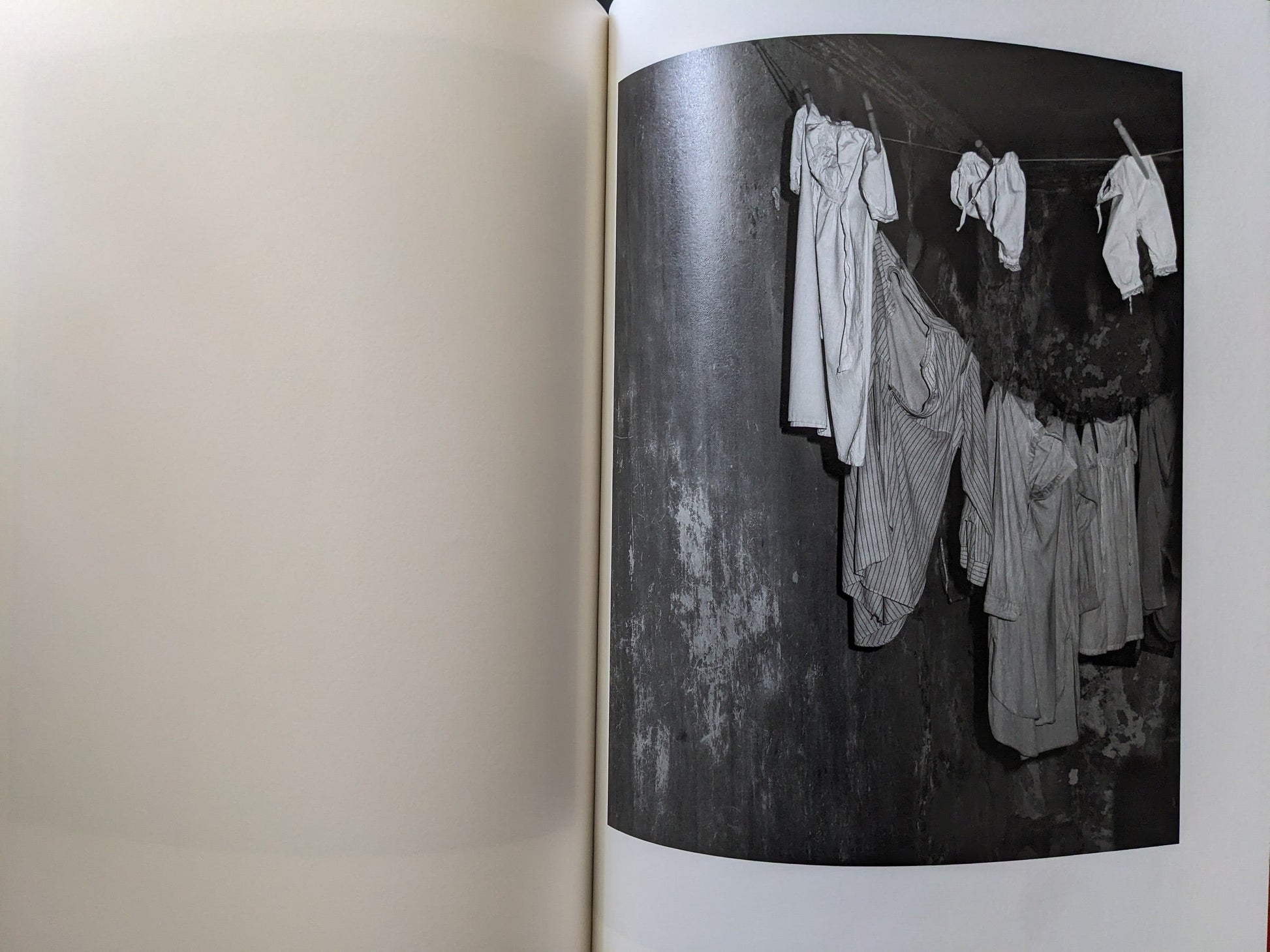Hanging white garments on a line inside a dim, aged cellar space.