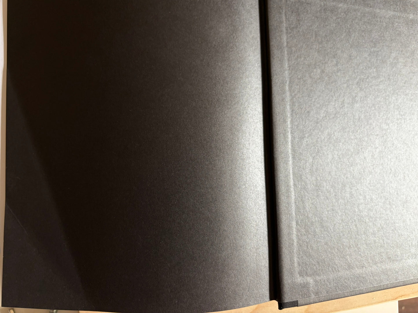 Dark endpaper spread with a faint crease visible near the lower left edge.