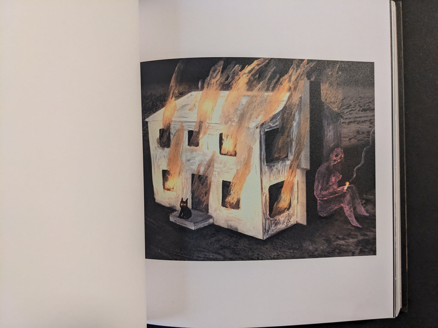 Artwork from The Fire That Drank The Shadow by Julia Soboleva of a white house on fire, with a small black cat in the foreground and a seated figure holding a small light to the side.