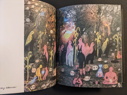 Open spread from The Fire That Drank The Shadow by Julia Soboleva, showing a forest scene with colorful figures, animals, and floating skull-like faces.