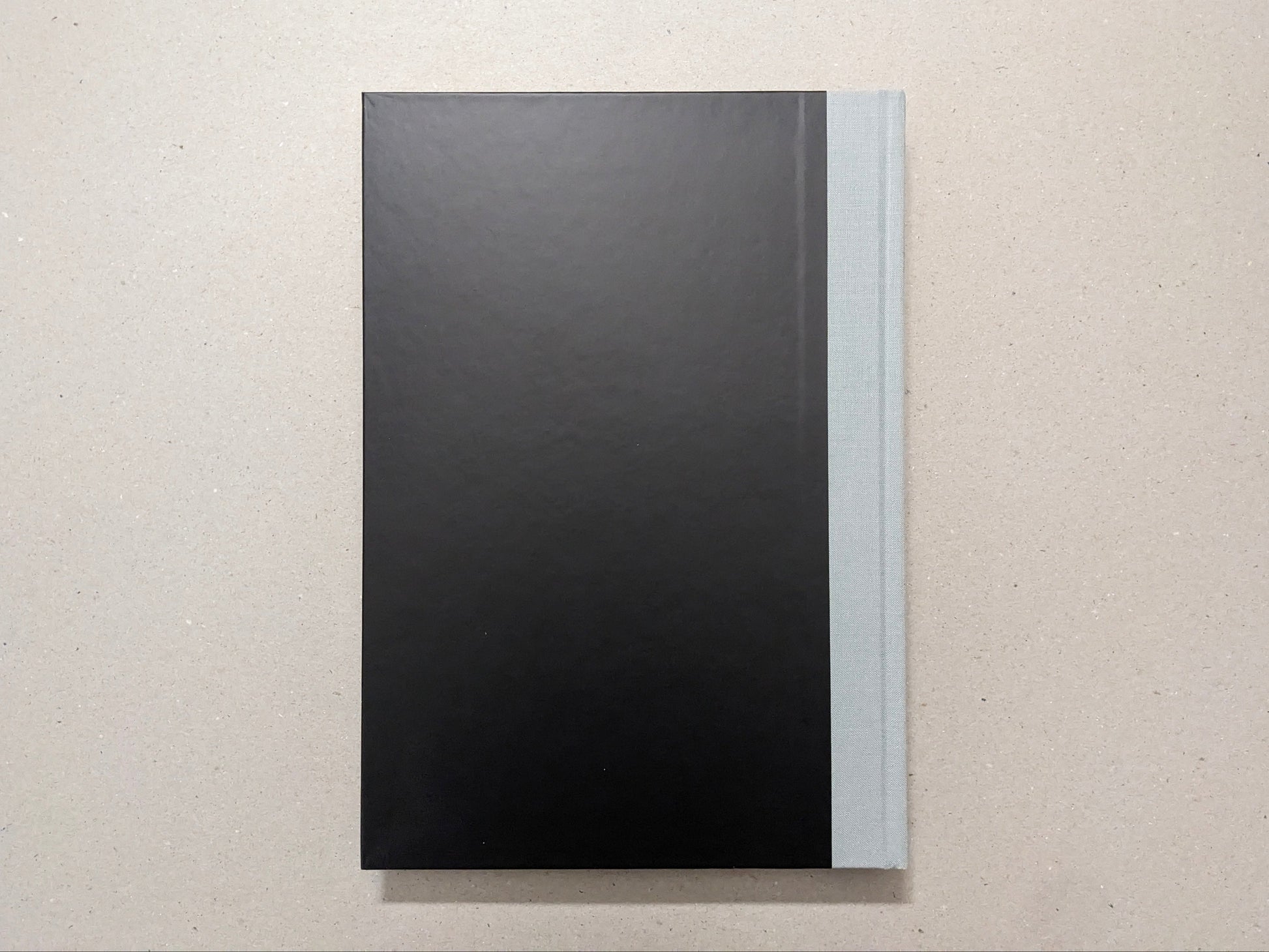 The Last Slogan Regular Edition back cover, minimalist black with a grey cloth spine