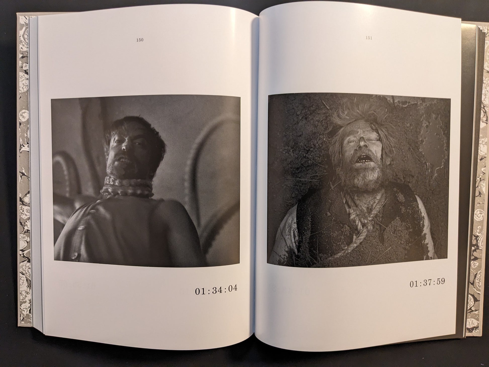 Double-page spread from The Lighthouse Screenplay Book featuring black-and-white stills of Robert Pattinson and Willem Dafoe.