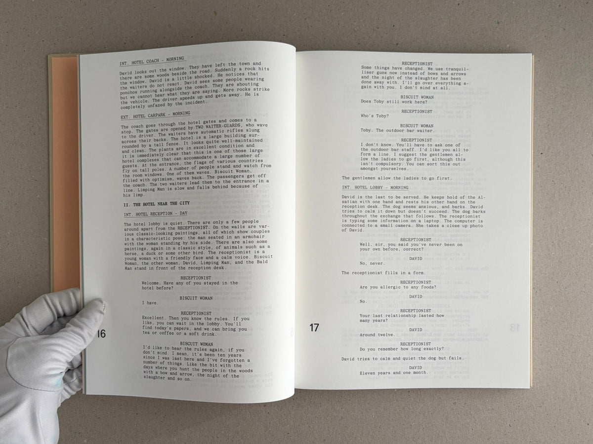 Open spread of The Lobster Screenplay Book showing screenplay text on pages 16 and 17, with a gloved hand holding the lower left corner.