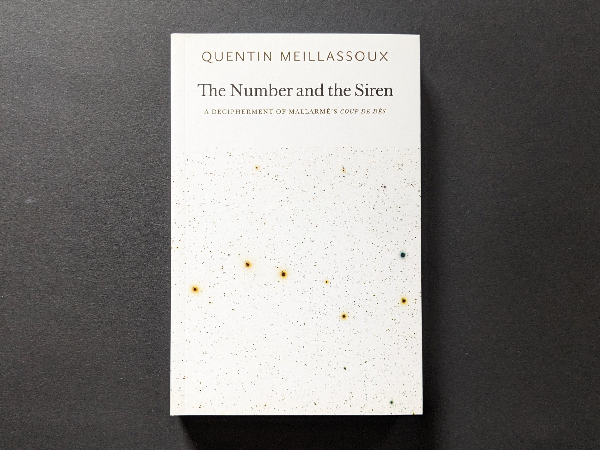 Front cover of The Number and the Siren by Quentin Meillassoux, featuring a minimalist white background with specks of color resembling a cosmic design.