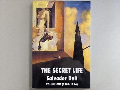 Front cover of "The Secret Life: Volume One (1904–1924)" by Salvador Dalí, featuring surrealist artwork with a window, a nude torso, and a distorted instrument-like form.