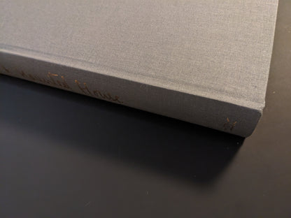 Book spine of The Universe is a Haunted House with gold embossed text on grey cloth cover.