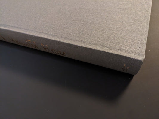 Book spine of The Universe is a Haunted House with gold embossed text on grey cloth cover.