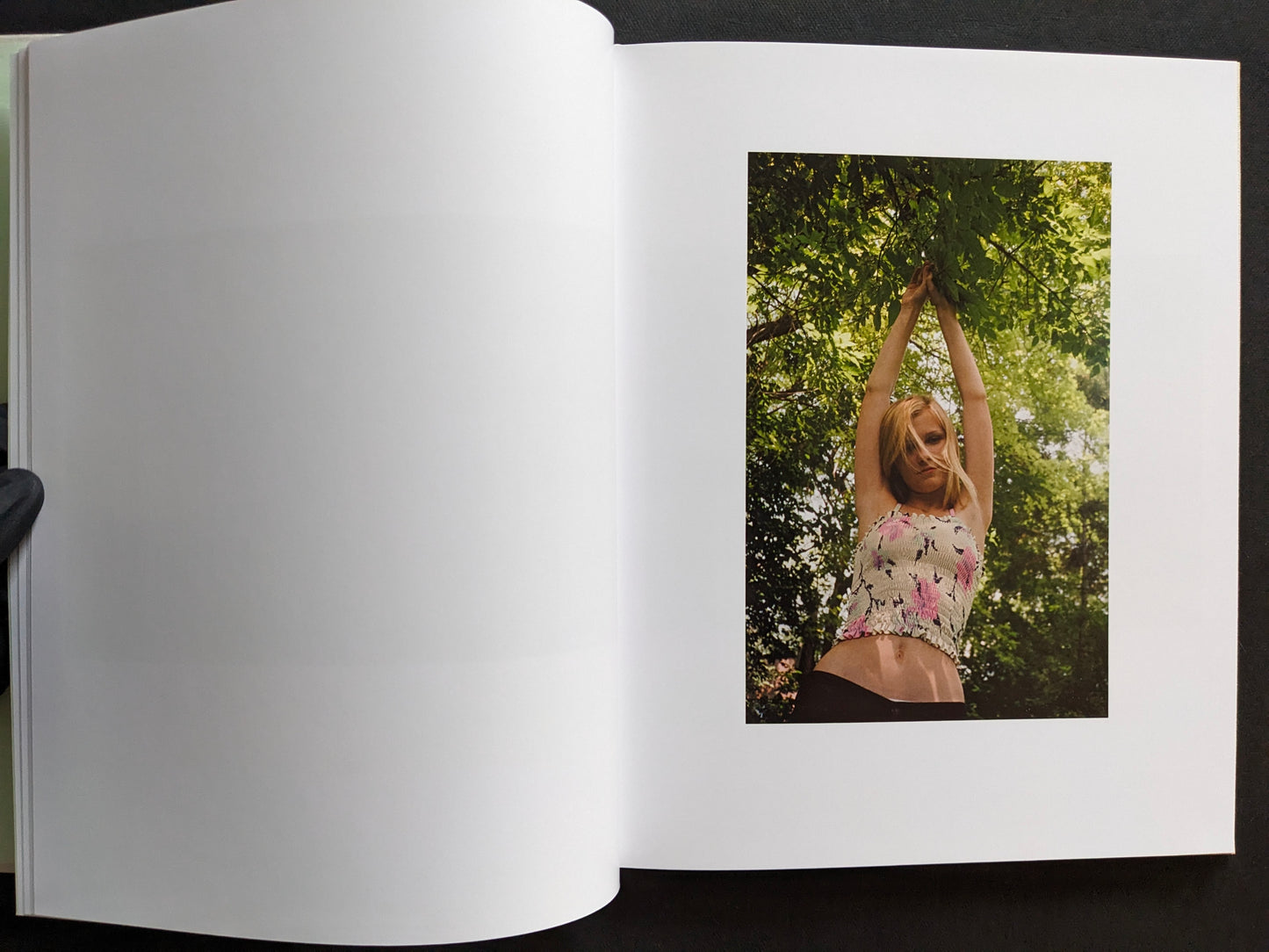 Interior page from The Virgin Suicides book showing a portrait of a girl standing under tree branches outdoors.