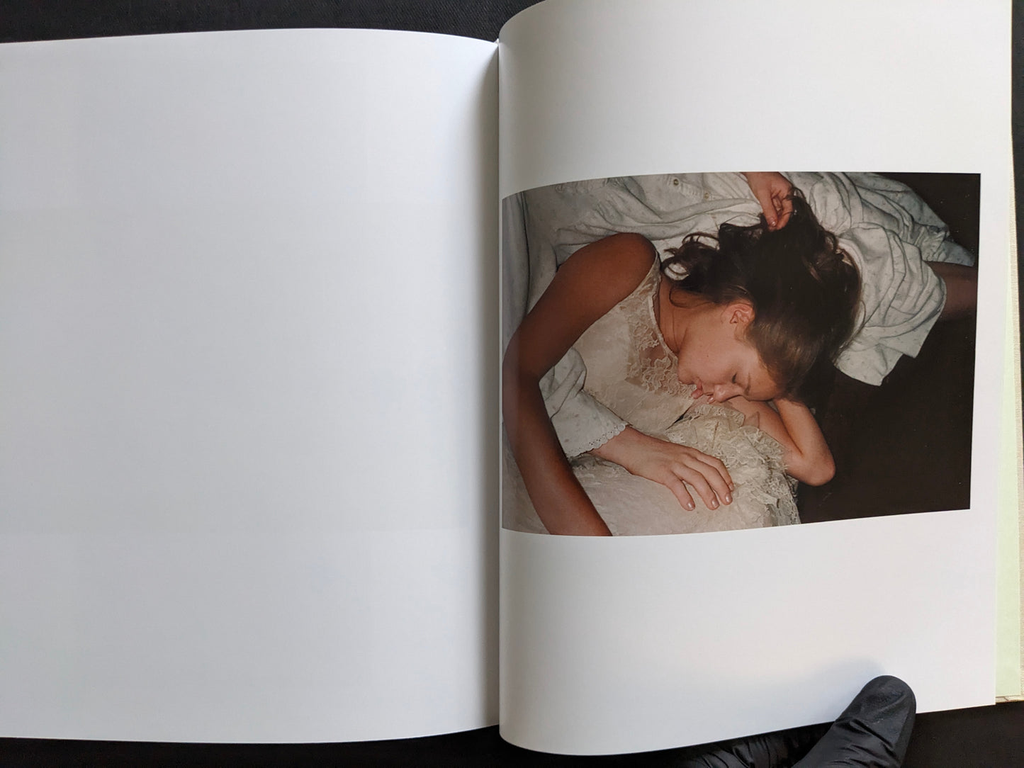 Interior page from The Virgin Suicides book showing a close photograph of a sleeping girl in a white dress.