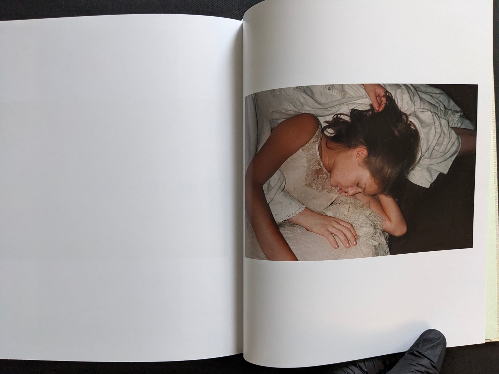 Interior page from The Virgin Suicides book showing a close photograph of a sleeping girl in a white dress.