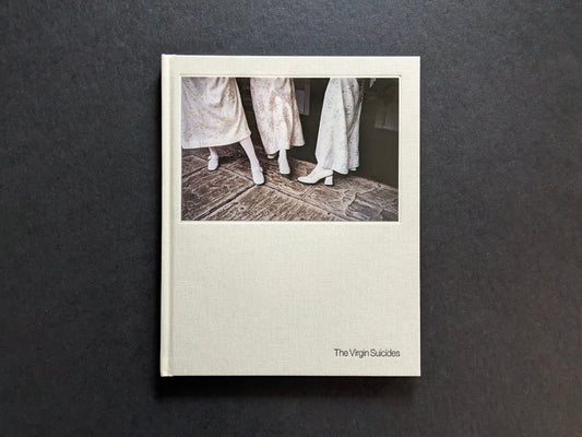 Front cover of The Virgin Suicides photobook by Sofia Coppola, with girls’ dresses and white shoes.