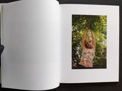 Interior page showing a portrait of a girl standing under tree branches outdoors.
