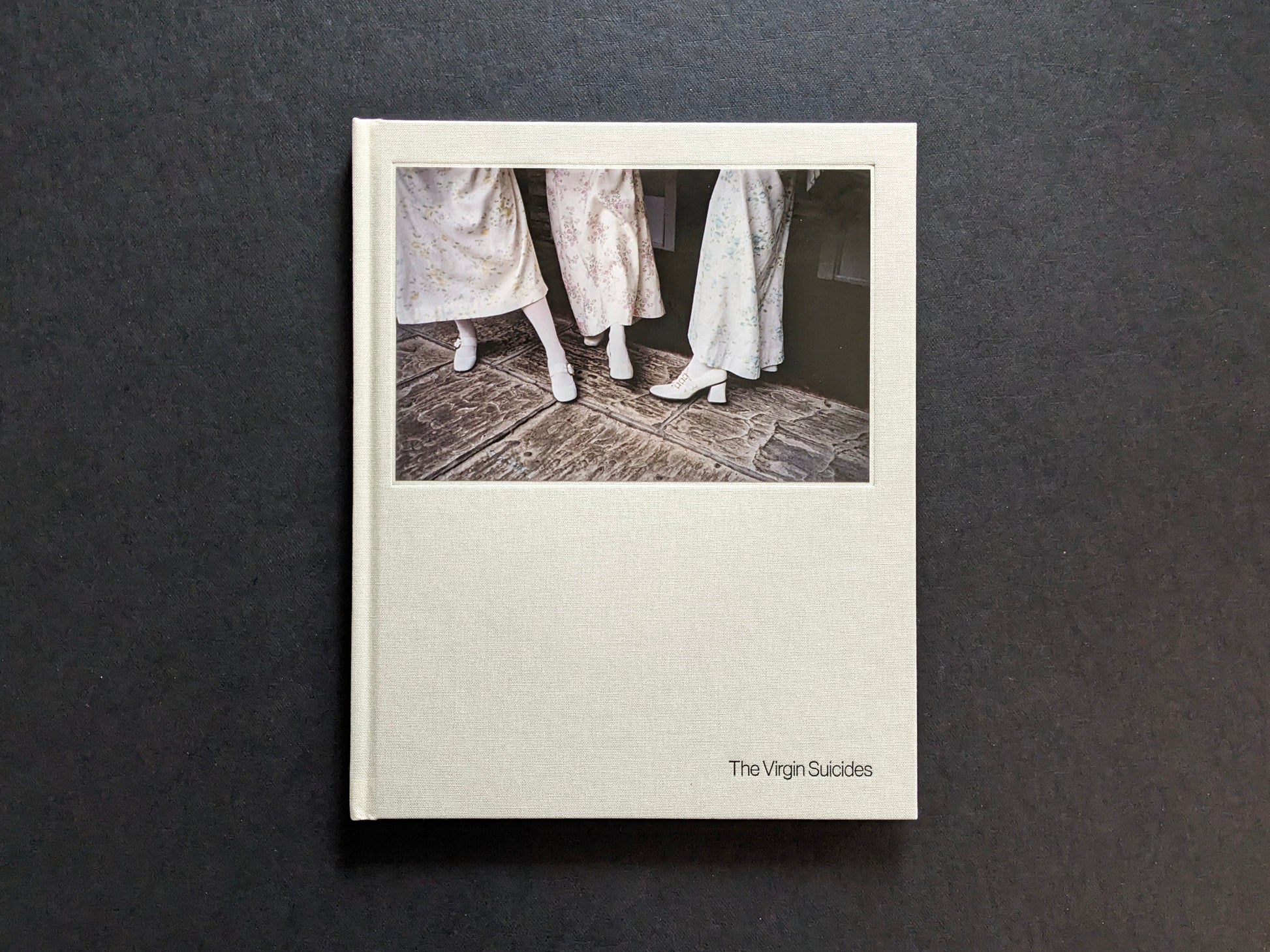 Front cover of The Virgin Suicides book by Sofia Coppola, featuring a photograph of girls’ dresses and white shoes.