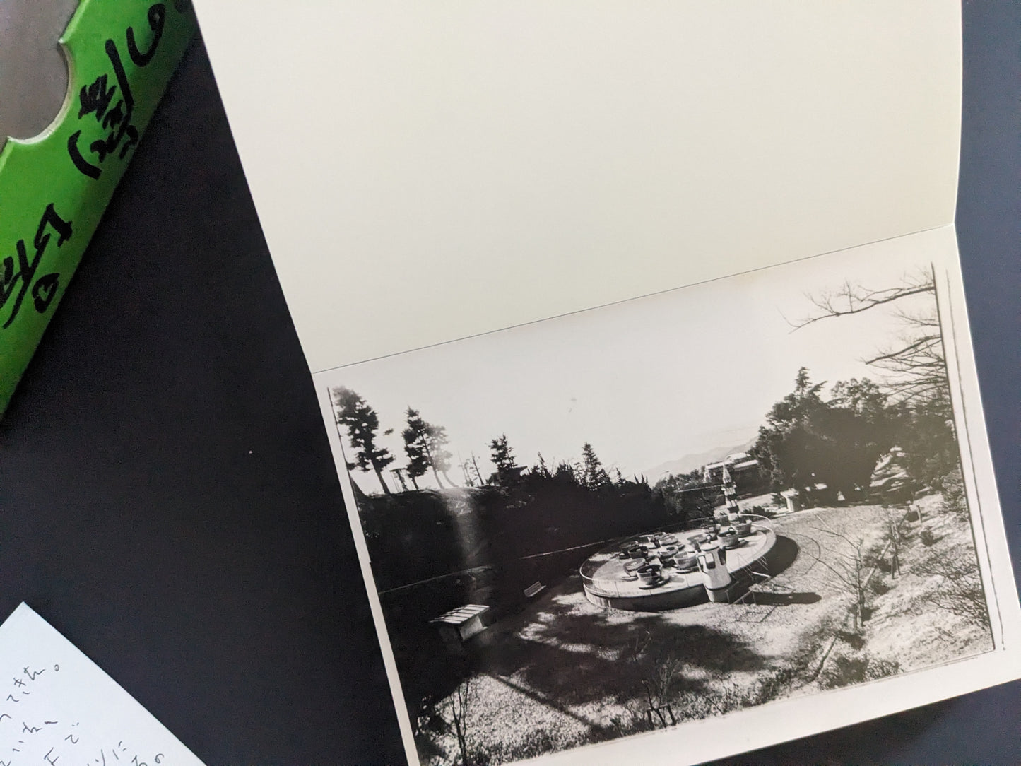 Black-and-white print of an empty amusement ride in a forest