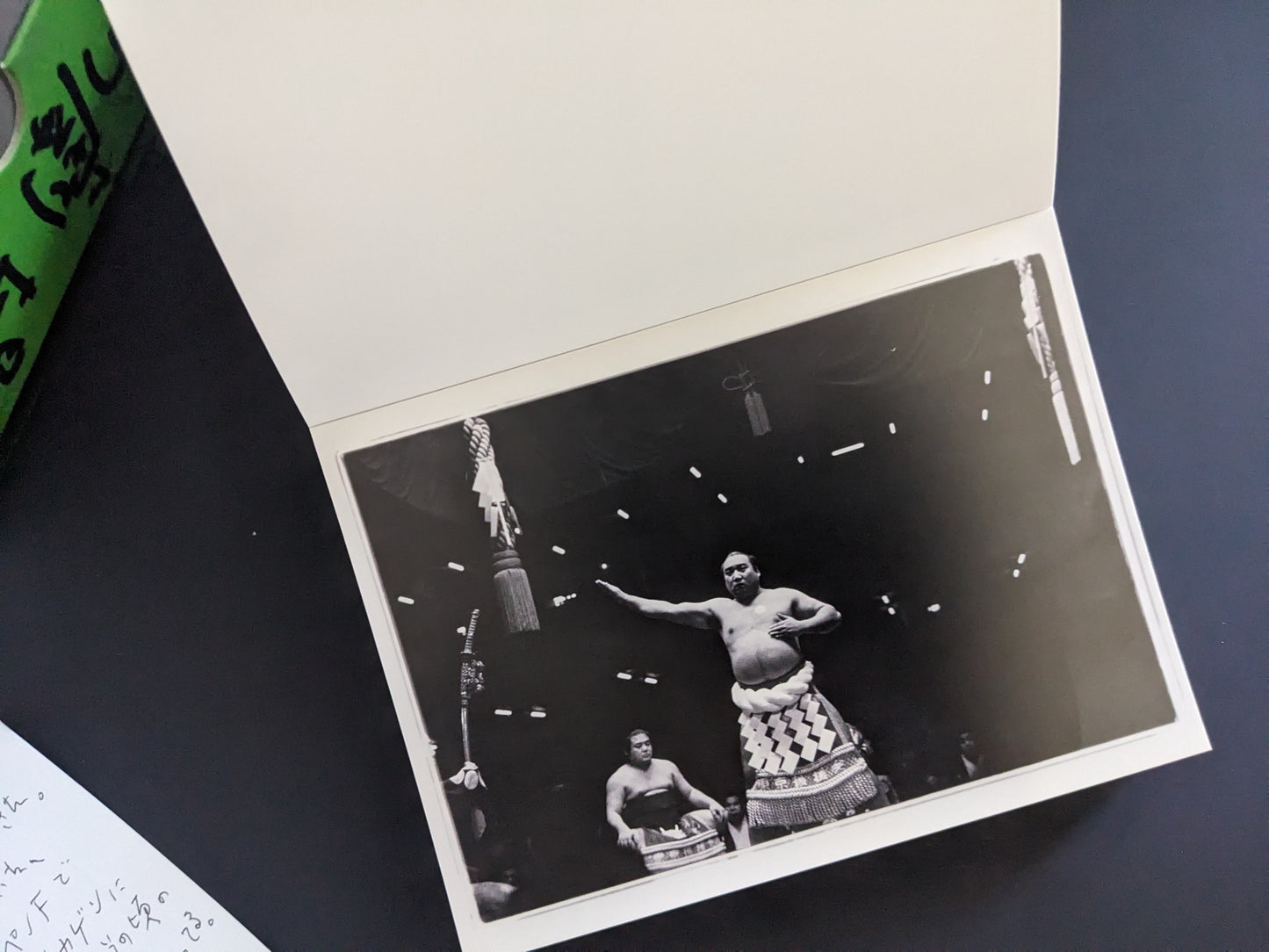 Photograph of a sumo wrestler in a ritual pose in the ring