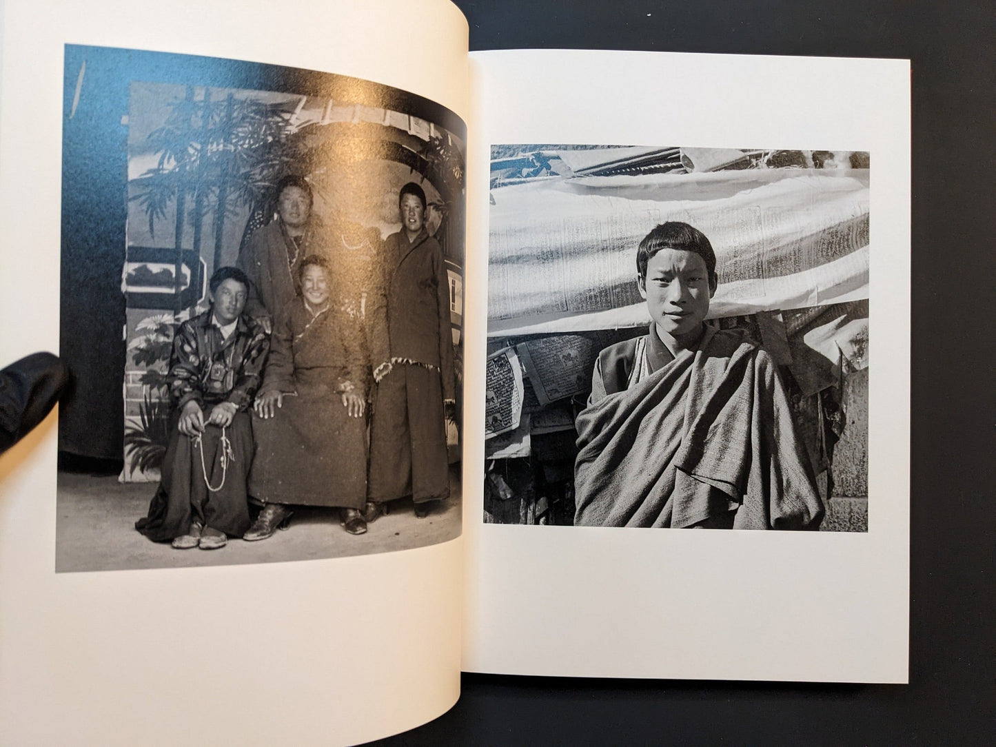 Spread from Tibet showing a family group and a young man standing by prayer flags.