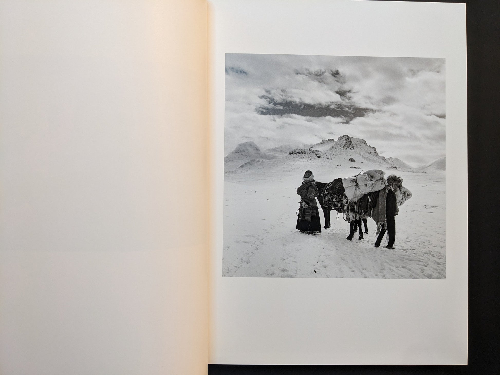 Inside page from Tibet showing two figures and a pack horse on a snowy plateau with mountains behind.