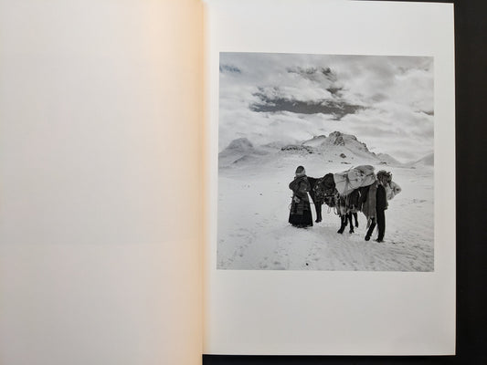 Inside page from Tibet showing two figures and a pack horse on a snowy plateau with mountains behind.