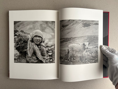 Open photobook spread with a black-and-white portrait and a mountain landscape, Tibet – Shinya Arimoto