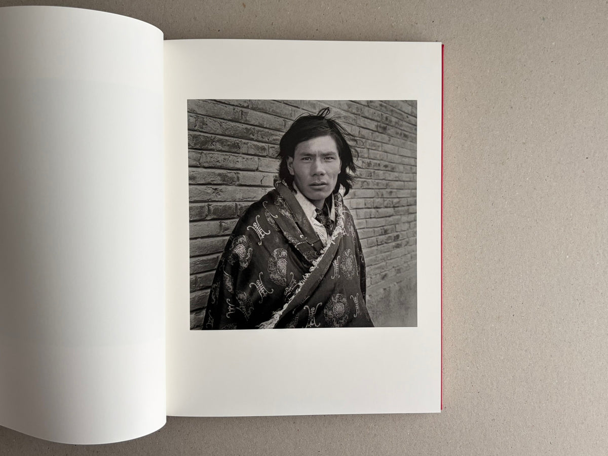 Open photobook spread with a black-and-white portrait on the right page, Tibet – Shinya Arimoto