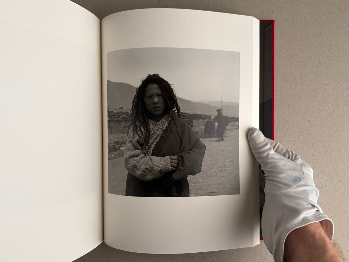 Open photobook spread with a black-and-white portrait on the right page, Tibet – Shinya Arimoto