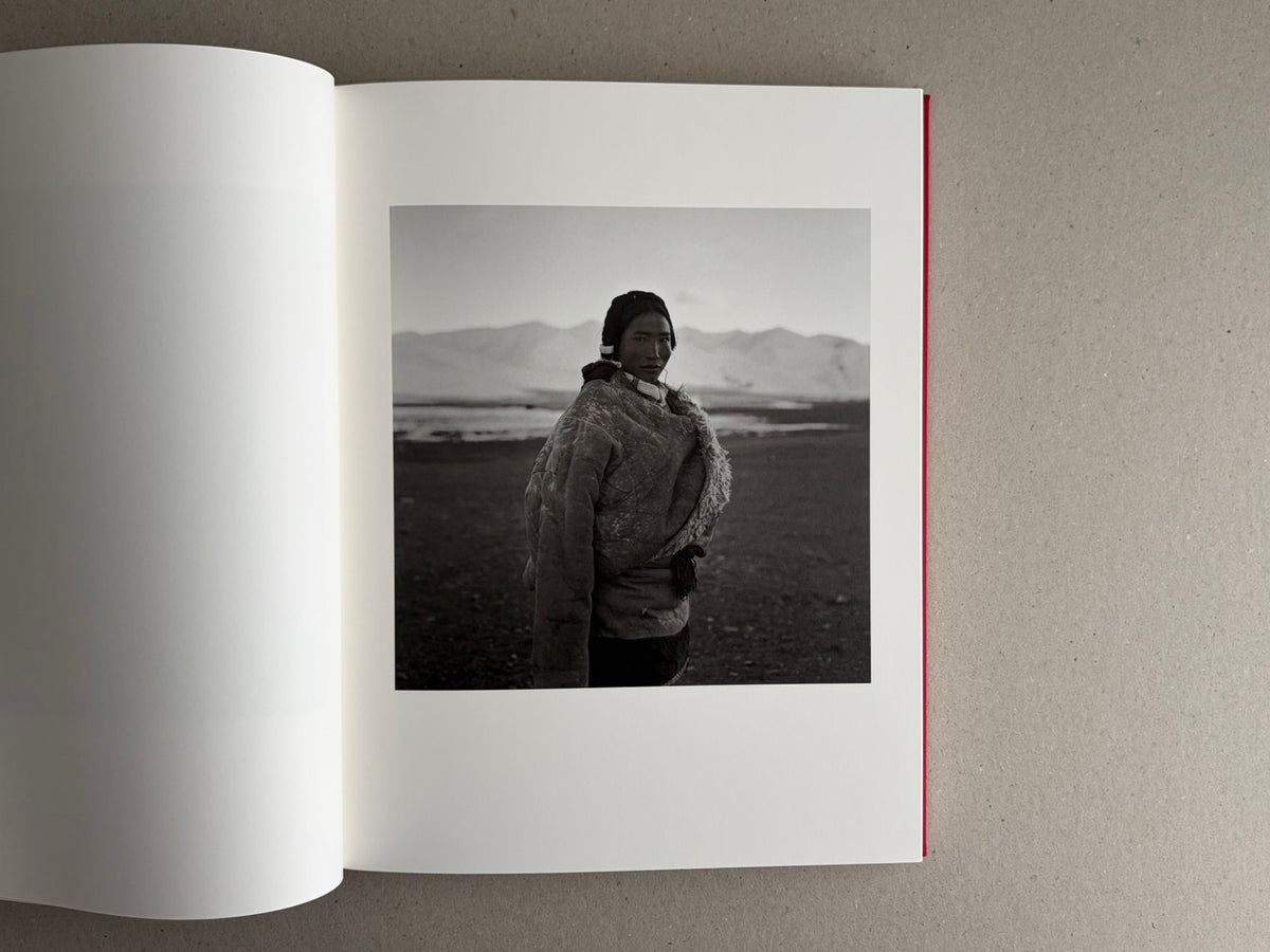 Open photobook spread with a black-and-white portrait on the right page, Tibet – Shinya Arimoto
