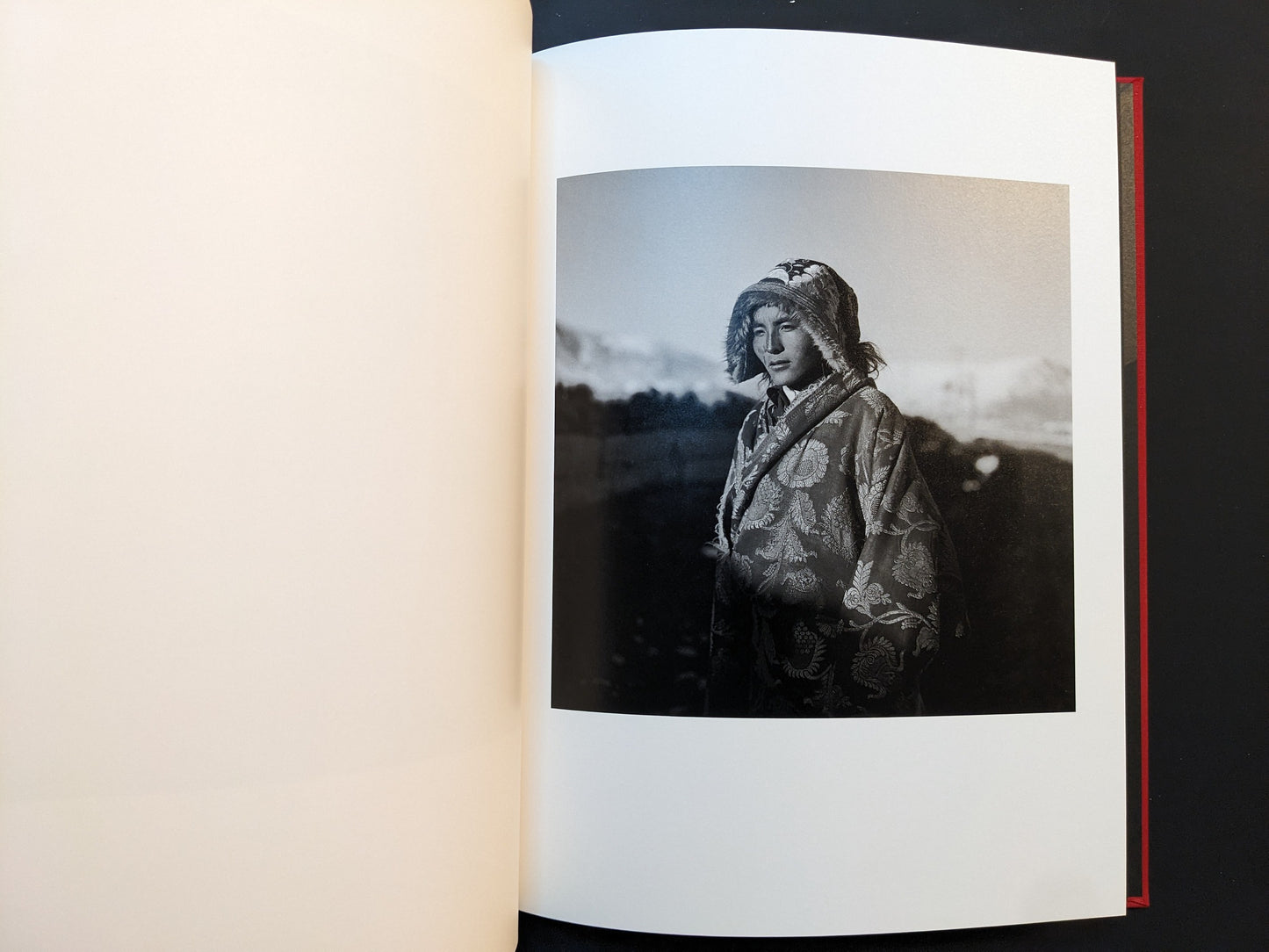 Inside page from Tibet with a portrait of a young woman in a patterned coat and hood outdoors.