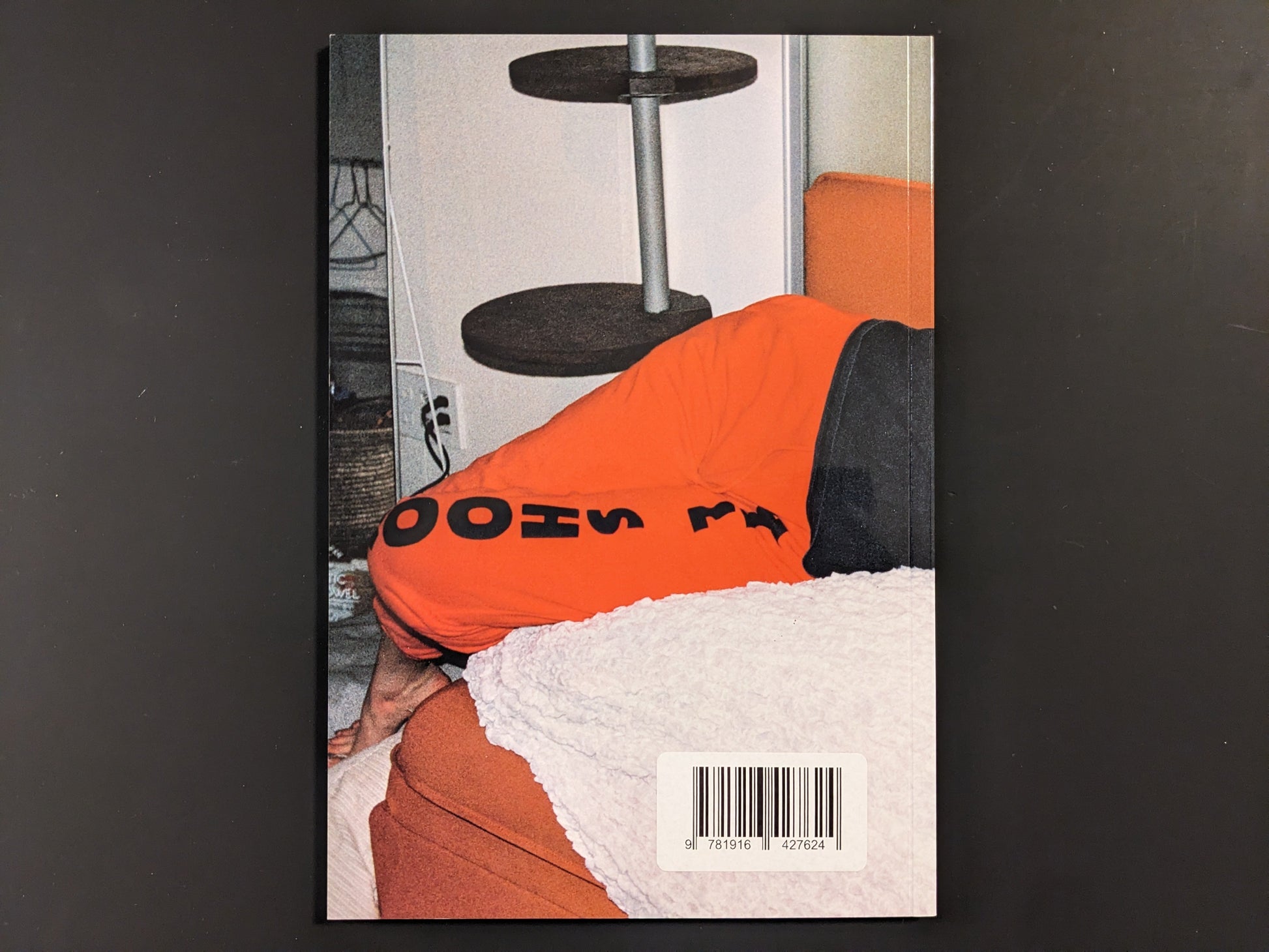Back cover of Tokyo Girls by Emily Ashcroft, showing partial view of a person in orange pants with bold black text.