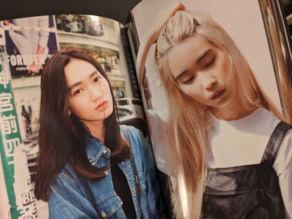 Portraits of two young women, one with blonde hair and closed eyes, another with long brown hair in front of city signs.