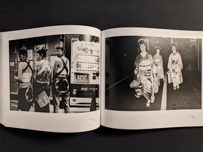 Spread from “Tokyo on the Brink of Sanity” with three costumed young men in front of vending machines and a group of women in ornate kimonos walking at night.