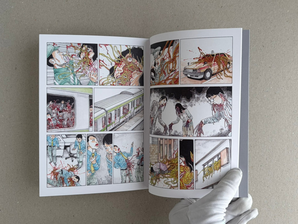 Open TRACT (pocket edition) by Shintaro Kago, showing a two-page comic spread with multiple panels and a gloved hand holding the book.