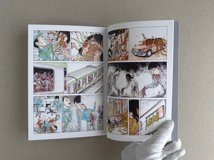 Open TRACT (pocket edition) by Shintaro Kago, showing a two-page comic spread with multiple panels and a gloved hand holding the book.