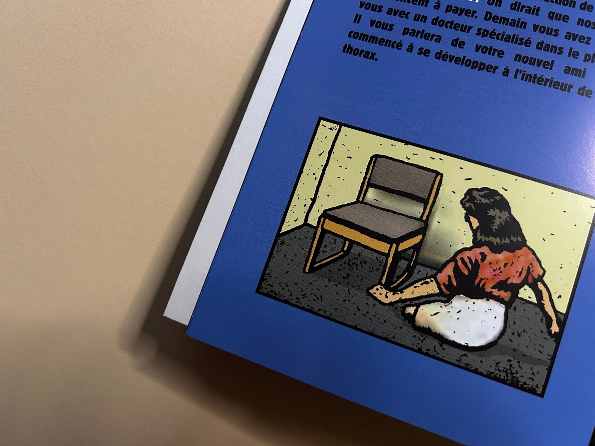 Traumavision interior page with a woman sitting on the floor beside a chair, next to a blue panel of French text.