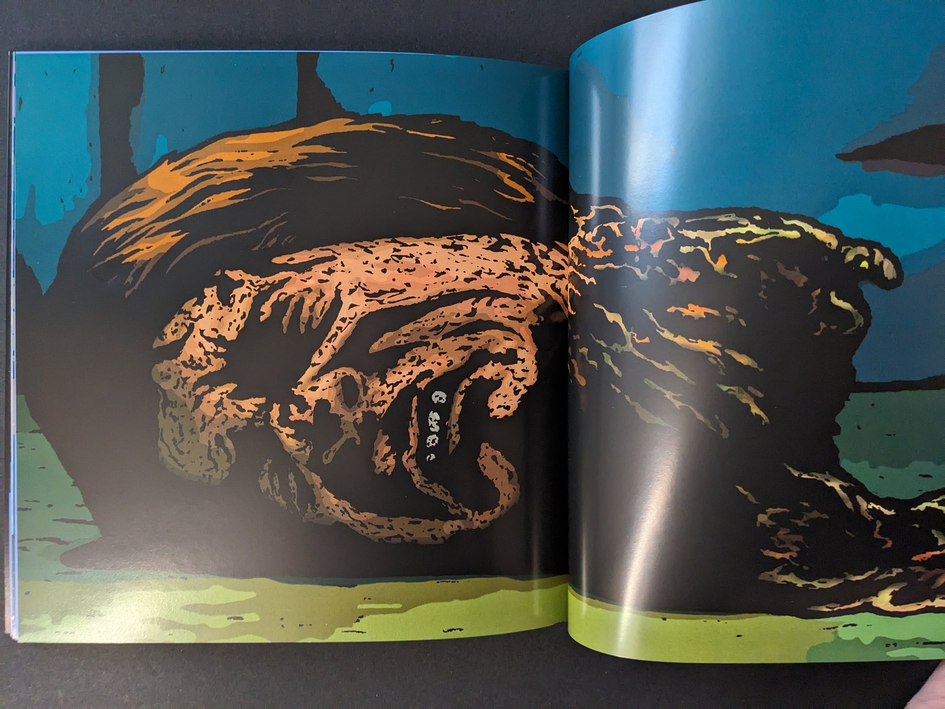 Traumavision interior spread with a distorted figure lying on the ground in a blue-toned scene.